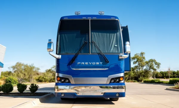 Head-on front view of the Astro Prevost entertainer coach in metallic blue with chrome bumper and mirrors