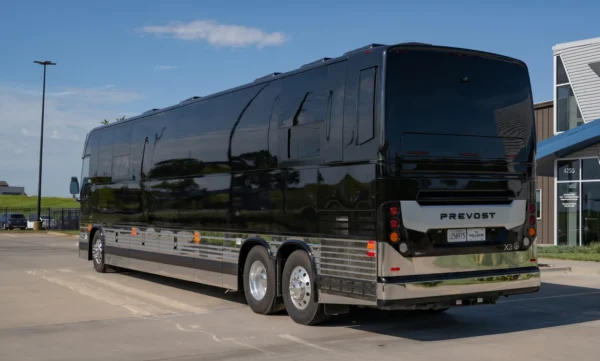 Rear three-quarter view of the Cash band bus, a gloss black Prevost X3 with chrome lower panels and tandem rear axles