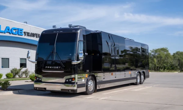 Cash entertainer bus in gloss black with side slide-out extended, parked outside Village Coach in Wichita